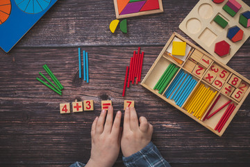 child is playing with wooden allowances, top view