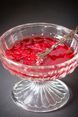 A glass vase with delicious bright translucent redcurrant jam