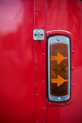 Vintage turn signal light of a red bus