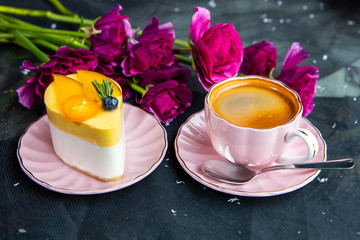 Top View Of Fresh Coffee Espresso In The Pink Mug And Delicious Cake On The Saucer. A Bouquet Of Flowers On The Background