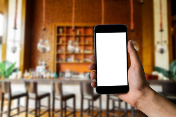 Hand holding white mobile phone with blank white screen  in cafe.