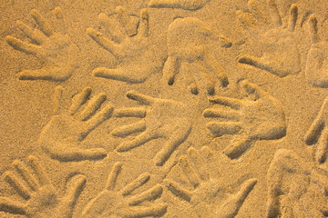 hand prints on yellow sand close up. natural surface texture
