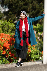 Femme beret et écharpe rouge jardin et massif d'hibiscus