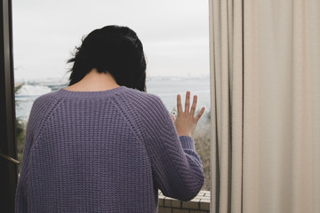 窓辺で落ち込む女性