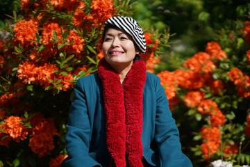 Femme beret et écharpe rouge jardin et massif d'hibiscus