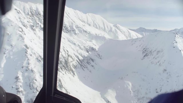 Point of view from pilot of a helicopter flying over the mountains of Siberia. Heliskiing in Siberia. POV