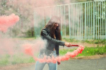 Beautiful brunette girl posing for photo with red smoke