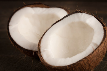 Ripe half cut coconut on a wooden background. Coconut cream and oil.