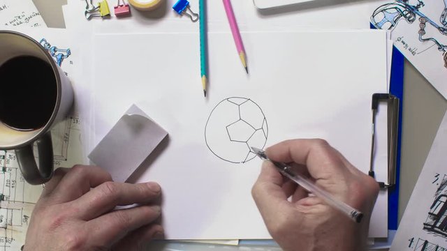 Hands make a sketch of a soccer ball