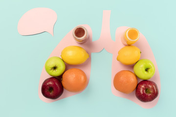 Detox food selection from fresh fruits in paper human lungs on blue background. Healthy food nutrition. Conceptual composition with copyspace