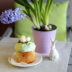 An Easter still life with home made traditional cake, hyacinths in the pot and  a porcelain rabbit decoration.