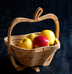 Pommes dans une corbeille à fruits sur fond noir