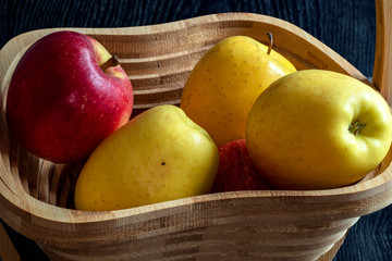 Pommes dans une corbeille à fruits sur fond noir