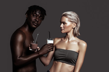 Model giving glass of chocolate drink to African-American boyfriend