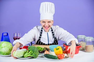 Woman chef cooking healthy food. Gourmet main dish recipes. Delicious recipe concept. Girl in hat and apron. Cooking healthy food. Fresh vegetables ingredients for cooking meal. Lets start cooking