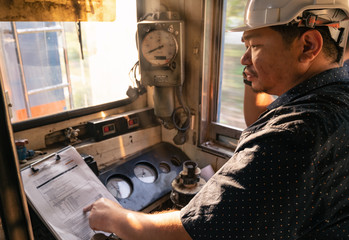 Train driver checking engine of train and gesture the hand to already from the station