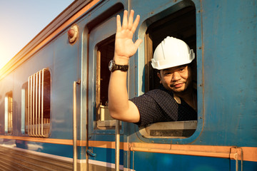 Train driver checking engine of train and gesture the hand to already from the station