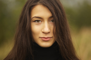 Naklejka premium Brunetki dziewczyna pozuje dla fotografii przy wioską