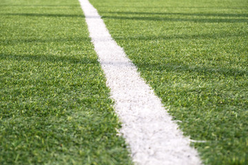 Fototapeta premium Artificial green grass with white stripe of soccer field