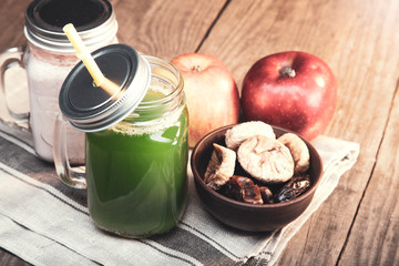 Green healthy smoothie in glass jar on rustik wood