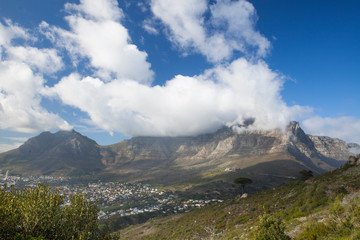 Obraz na płótnie Canvas Clouds spilling over Table Mountain on a clear day, Cape Town, South Africa