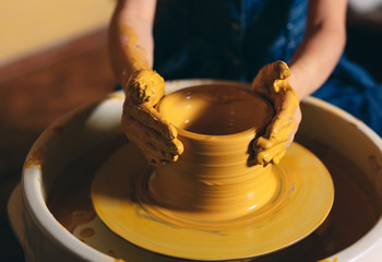 Pottery workshop. A little girl makes a vase of clay. Clay modeling