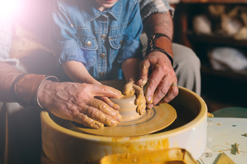 Pottery workshop. Grandpa teaches granddaughter pottery. Clay modeling