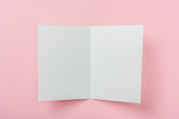 Fototapeta na wymiar white blank greeting card on pink background with copy space