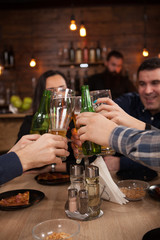 Group of happy friends drinking and toasting beer at brewery bar restaurant.