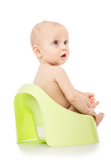 Infant child baby boy toddler sitting on potty toilet isolated on a white background. spoiled kid...