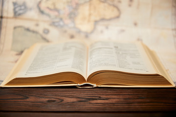 Selective focus of book and map on wooden table