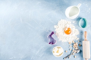 Easter baking culinary background with ingredients and props, on a light blue concrete background top view copy space