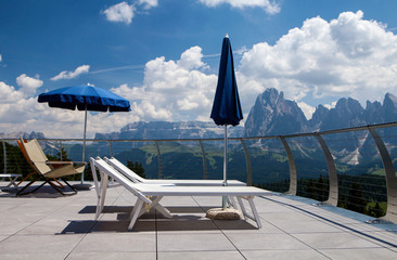 Fototapeta na wymiar Deckchairs on the terrace with the mountain view, Dolomites, Ital