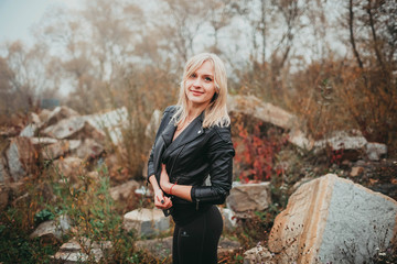 on the beach and stones background. blonde girl posing