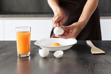 Attractive healthy woman waring apron making omelette