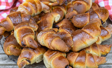 Tasty and fresh homemade croissants on a wooden background with a red cloth