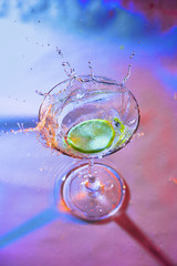 colorful cocktail in glass with splashes and lemon