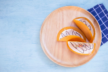 Sweet crispy Thai pancake on wooden tray with space on blue background