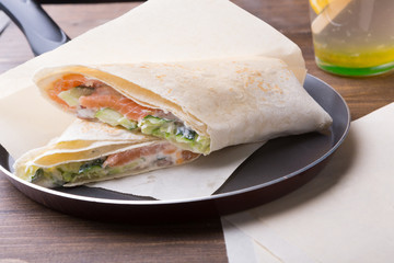 Salmon roll wrap served on a wooden board