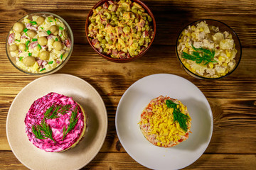 Set of festive mayonnaise salads on wooden table. Top view