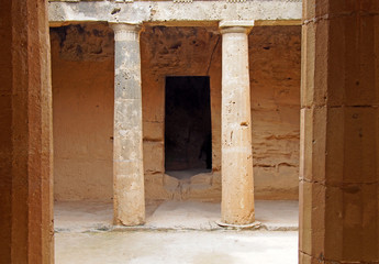 an underground chamber at the tombs of the kings in paphos cyprus with old eroded sandstone columns...