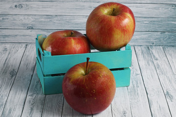 Fresh red apples on white wooden background