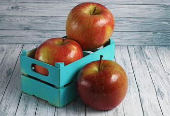 Fresh red apples on white wooden background
