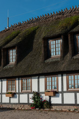 Reetdachhaus mit Fachwerk und Sprossenfenstern