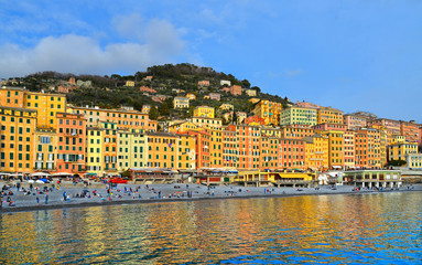 Naklejka premium Glimpse of historical Old Town Camogli and sand beach with crowd of people on mediterranean coast in Camogli, italian Riviera, Italy