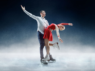 Professional man and woman figure skaters performing show or competition on ice arena