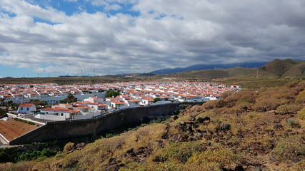 Fototapeta na wymiar Views from the vantage point of the nearby hill towards the residential part of the remote village of Abades, previously known as Los Abriguitos, in the south-east of Tenerife, Canary Islands, Spain