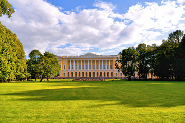 Obraz premium St Petersburg, Russia Northern facade of Mikhailovsky palace, building of the State Russian museum with green park with people and scenic blue cloudy sky.