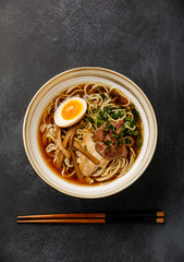 Ramen asian Noodle in broth with Meat and Ajitama pickled Egg in bowl on dark background