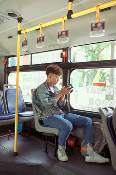 HO CHI MINH CITY, VIETNAM - 22 JULY, 2017: Young asian man taking a photo on bus with her digital camera